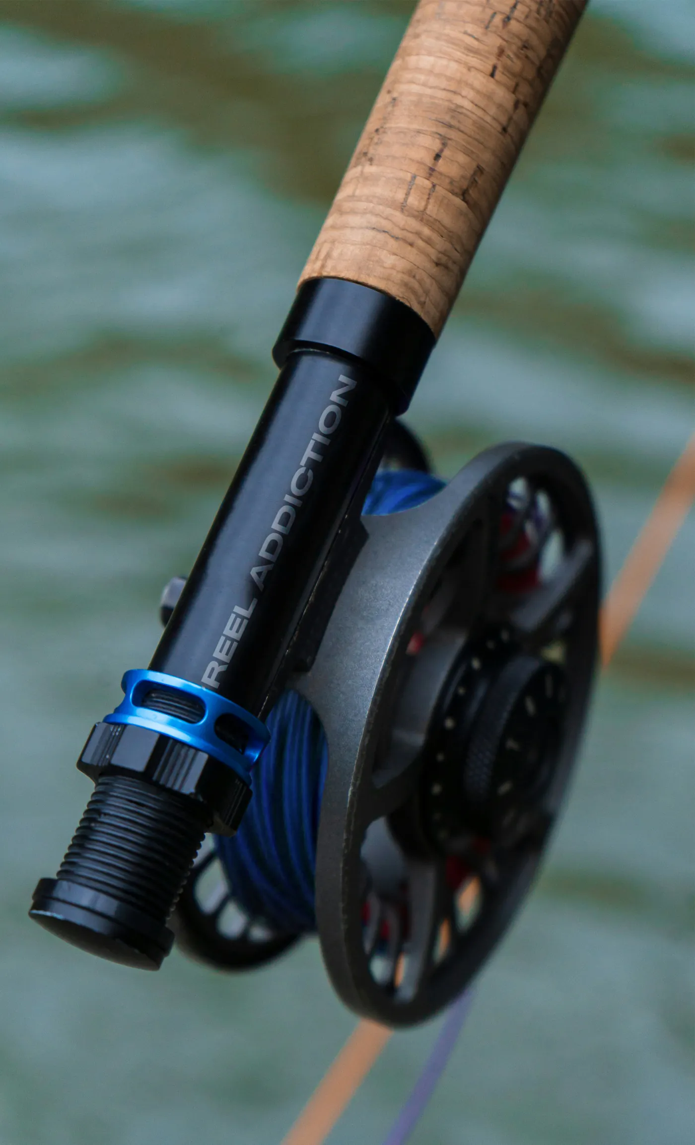 Reel Addiction branded fly reel and cork-handled rod over the lagoon