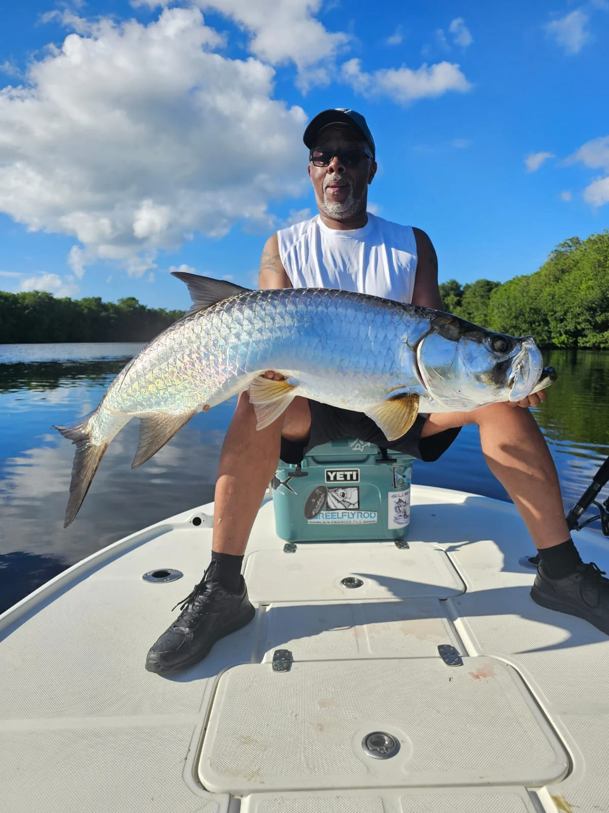 Angler with a tarpon along the mangrove shoreline